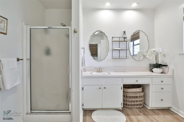 bathroom featuring a stall shower, wood finished floors, and vanity