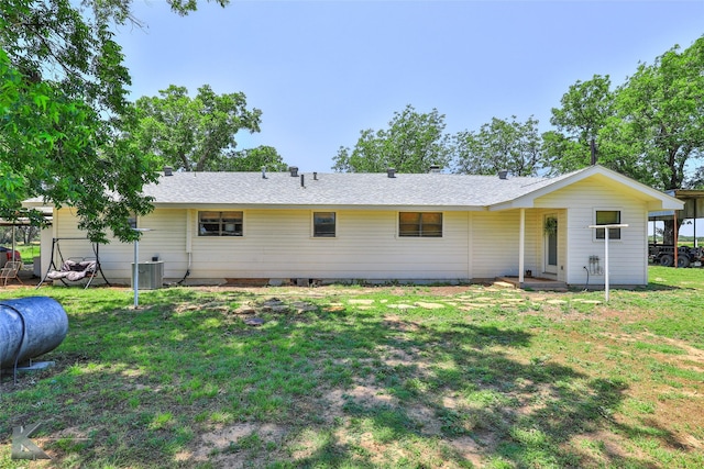 rear view of house with a lawn and central air condition unit