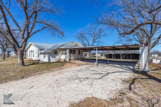 view of front of home with a carport and gravel driveway