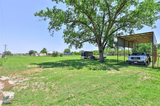 view of yard featuring fence and a carport