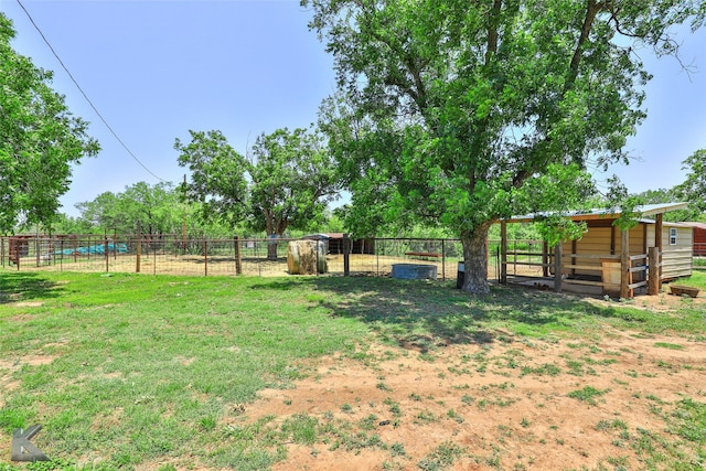 view of yard with a rural view, an exterior structure, and an outbuilding