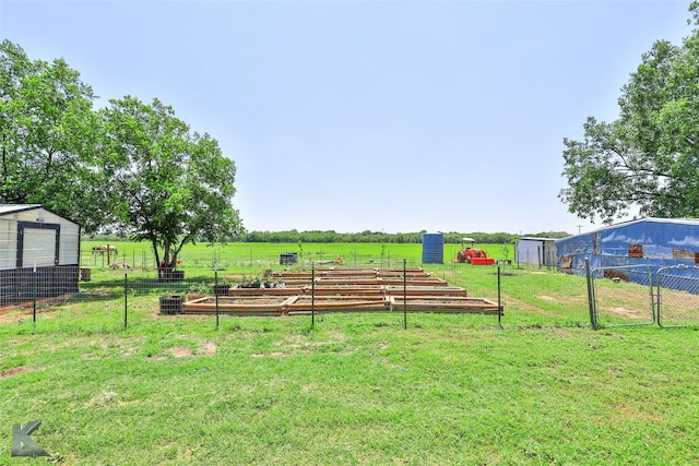 view of yard featuring a garden, fence, and a rural view