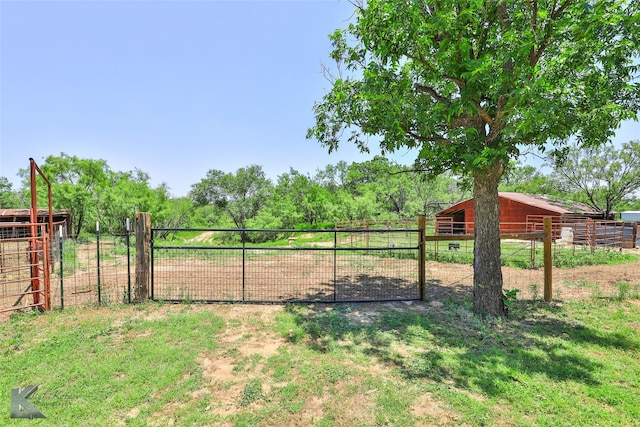 view of yard with a rural view, fence, an outdoor structure, and an exterior structure