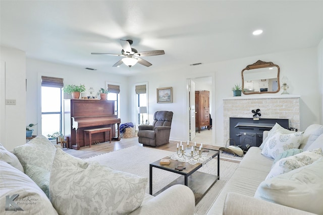 living room featuring a ceiling fan, light wood-type flooring, visible vents, and recessed lighting