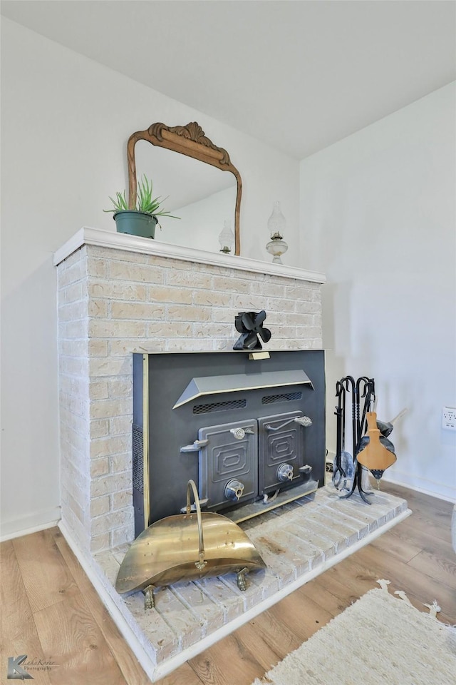 details featuring a fireplace and wood finished floors