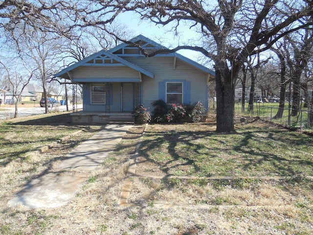 view of front of house featuring fence, a porch, and a front yard