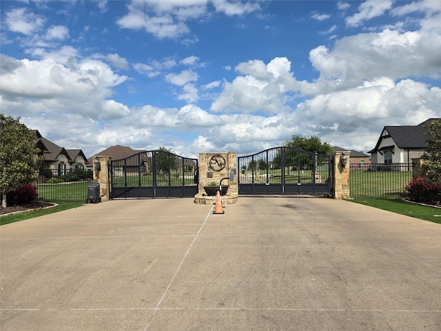 view of gate with fence and a residential view