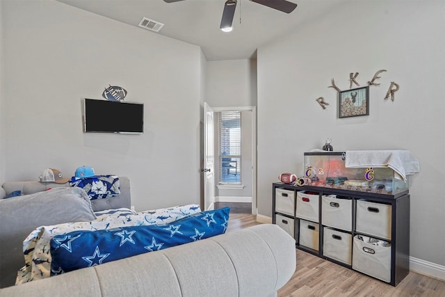 living area with visible vents, ceiling fan, light wood-style flooring, and baseboards