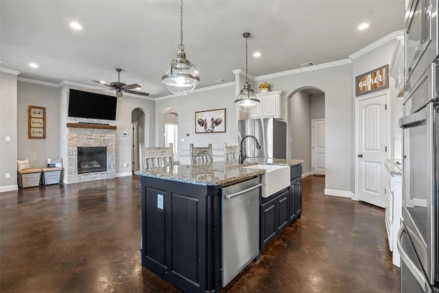 kitchen featuring a sink, arched walkways, finished concrete flooring, and appliances with stainless steel finishes