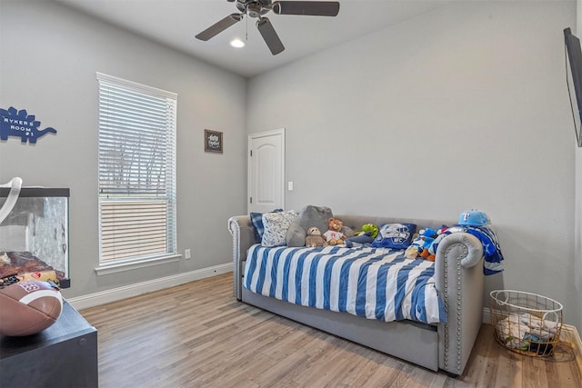 bedroom featuring a ceiling fan, light wood-style flooring, and baseboards