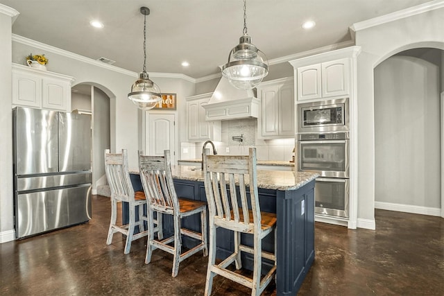 8500 Cobble Stone, Godley, TX 76044 - kitchen featuring appliances with stainless steel finishes, arched walkways, baseboards, custom range hood, and finished concrete floors