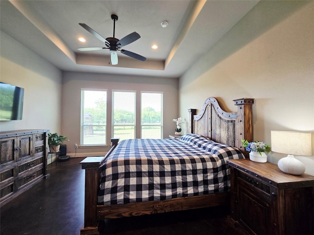 bedroom featuring finished concrete flooring, a ceiling fan, a tray ceiling, and recessed lighting