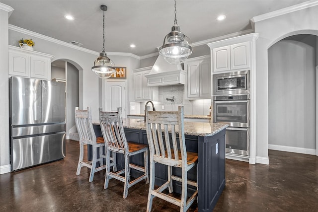 kitchen with white cabinets, arched walkways, stainless steel appliances, and decorative light fixtures