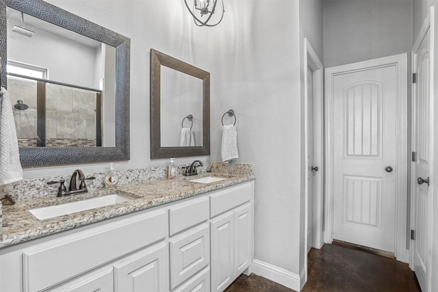 bathroom featuring a sink, baseboards, concrete flooring, and double vanity