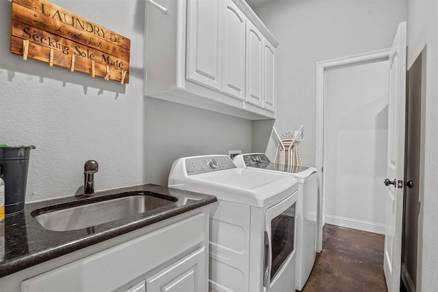 laundry room with separate washer and dryer, a sink, and cabinet space