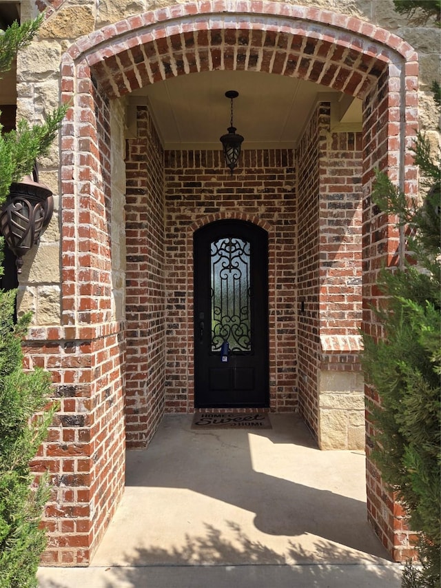 entrance to property featuring brick siding
