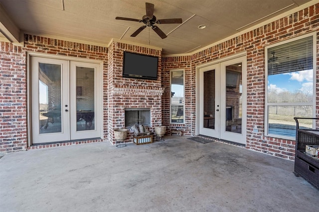 view of patio with french doors, an outdoor brick fireplace, and a ceiling fan