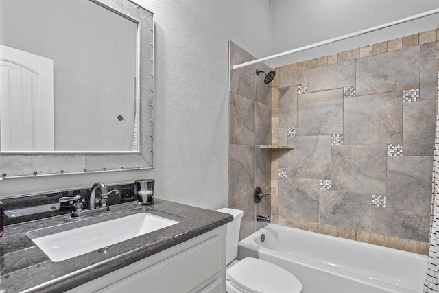 full bathroom with toilet, a textured wall, washtub / shower combination, and vanity