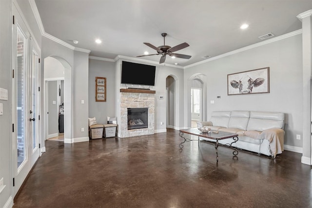 living area featuring arched walkways, a stone fireplace, recessed lighting, visible vents, and baseboards