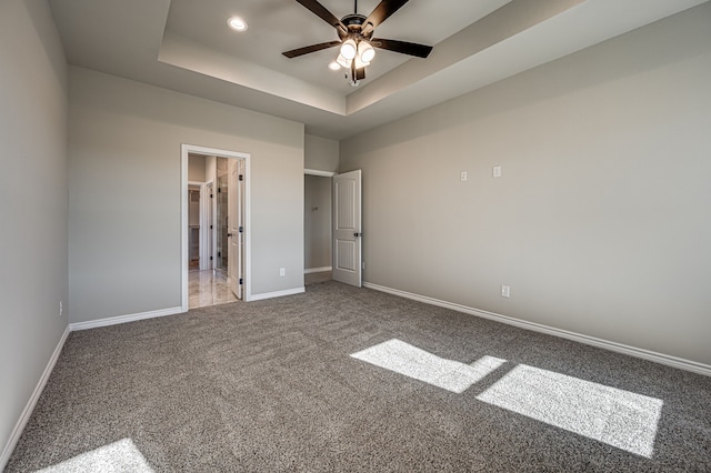 unfurnished bedroom with carpet, a raised ceiling, baseboards, and recessed lighting