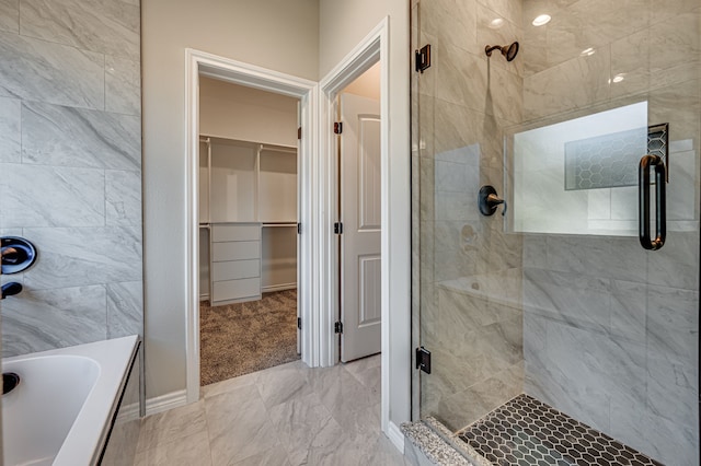 full bath featuring a garden tub, a shower stall, and a walk in closet