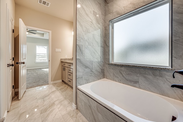 full bathroom with a bathing tub, vanity, visible vents, baseboards, and marble finish floor