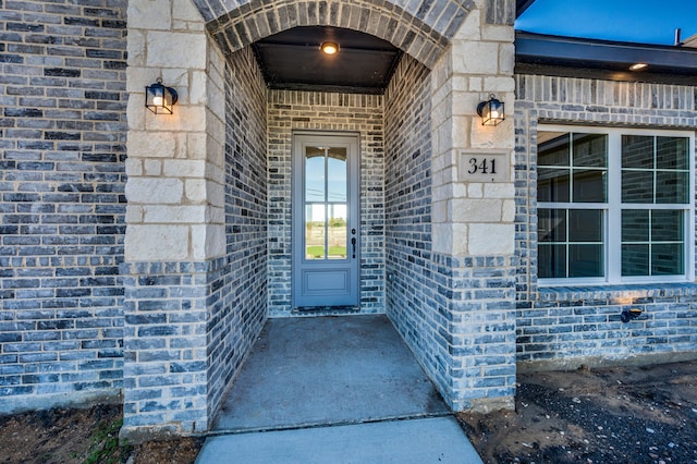 doorway to property featuring stone siding and brick siding