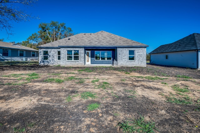 rear view of property with brick siding and fence