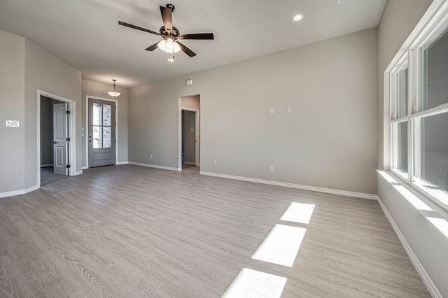 spare room with a ceiling fan, recessed lighting, light wood-style flooring, and baseboards