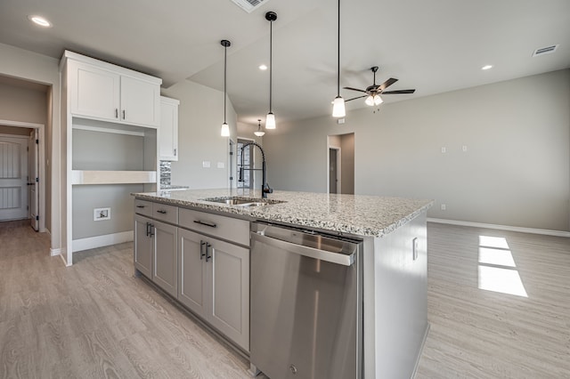 kitchen featuring a kitchen island with sink, a sink, white cabinets, stainless steel dishwasher, and light stone countertops