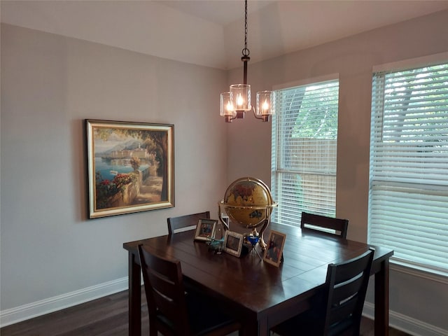 dining room featuring a notable chandelier, dark wood finished floors, and baseboards