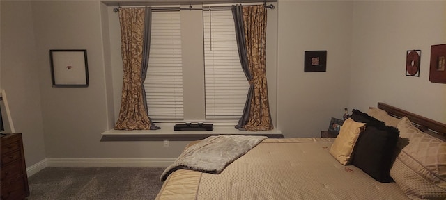 bedroom featuring dark colored carpet and baseboards