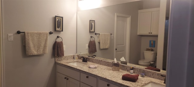 bathroom with a closet, a sink, and double vanity