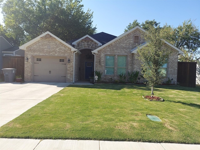 ranch-style home with fence, driveway, an attached garage, a front lawn, and brick siding