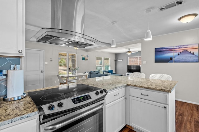 kitchen with visible vents, island range hood, white cabinets, electric stove, and open floor plan