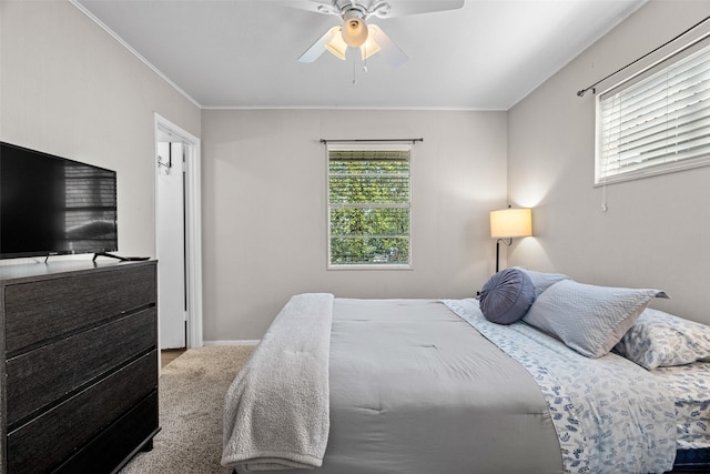 bedroom featuring ceiling fan, ornamental molding, and light colored carpet