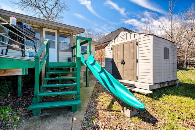 view of playground with a storage unit and an outbuilding