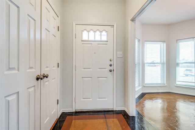 entryway featuring concrete flooring and baseboards