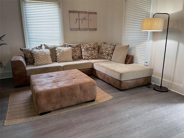 living area with baseboards and wood finished floors