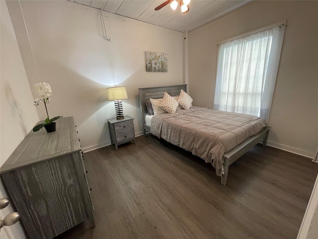 bedroom with a ceiling fan, baseboards, and dark wood-type flooring