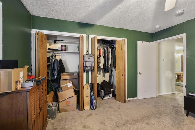 carpeted bedroom featuring multiple closets and a textured ceiling