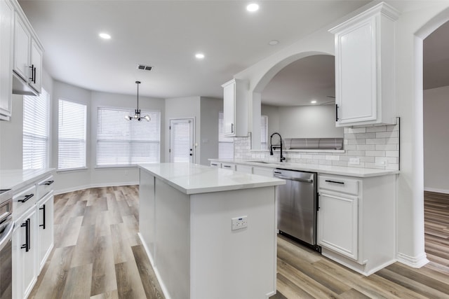 kitchen featuring dishwasher, light countertops, white cabinets, and a center island