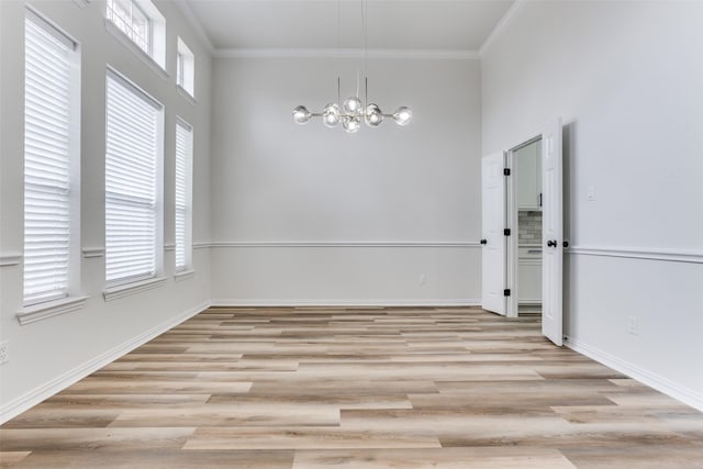 unfurnished dining area featuring light wood finished floors, a healthy amount of sunlight, and crown molding