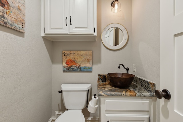 half bathroom featuring toilet and vanity