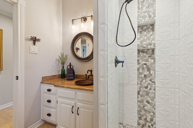 bathroom featuring vanity, baseboards, and tiled shower