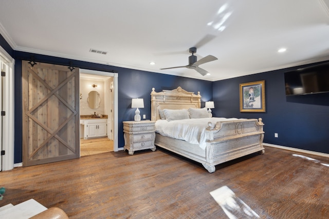 bedroom featuring a barn door, visible vents, wood finished floors, and crown molding