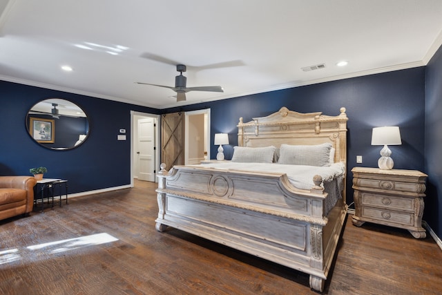 bedroom with visible vents, wood finished floors, a barn door, and ornamental molding