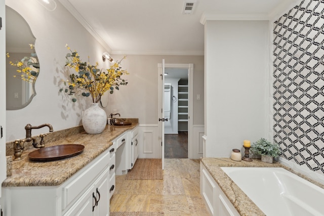 full bath featuring ornamental molding, a bath, visible vents, and a sink