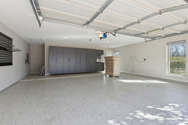 garage featuring electric panel, a garage door opener, and baseboards