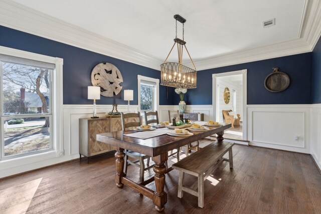 dining area with dark wood-type flooring, a notable chandelier, a healthy amount of sunlight, and visible vents